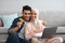 Joyful pregnant islamic couple using laptop and credit card for online shoping