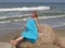 The joyful pregnant woman has a rest on the bank of the Baltic Sea