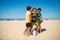 Joyful preteen boys embracing after game on beach