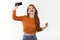 Joyful and relaxed, carefree redhead hipster girl carried away with music, dancing raise hand up with smartphone