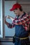 Joyful repairman installing the window in the kitchen