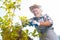 Joyful retired man having great time in the garden