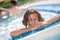 Joyful school-age boy looking out of pool