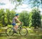 Joyful senior biker riding a bicycle in a park