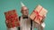 Joyful senior man with party hat and gifts, teal background