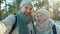 Joyful senior man and woman making online video call from forest in winter talking looking at camera