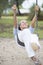 Joyful senior woman on swing active retirement