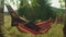 Joyful serene african female tourist sleeping in hammock on mountain hill at dawn