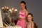 Joyful Sisters Posing at Piano Decorated with Burning Candles