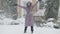 Joyful slim charming woman cleaning snow with shovel and spinning laughing outdoors. Wide shot portrait of cheerful