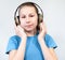 Joyful small girl portrait wearing big wireless headphones. Pretty child eleven years old listening to the music