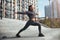 Joyful sporty woman performing a warm-up exercise outdoors