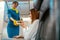 Joyful stewardess giving cookies to woman in airplane