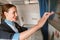 Joyful stewardess using touchscreen display in airplane