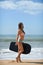 Joyful surfer girl happy cheerful running surfing at ocean beach water. Female bikini heading for waves with surfboard