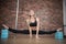 Joyful talented woman doing the splits in pole dance studio and smiling