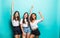 Joyful tanned three european girls posing with pleasure during rest with friends. Funny african young woman dancing in studio