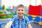 Joyful teenage boy having fun on roundabout, playground