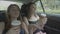 Joyful teenage girls going on vacation dancing and drinking coffee enjoying travel in a car