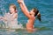 Joyful teenager girls playing at sea water