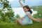 Joyful teenager sitting in the grass