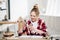 Joyful teenager sitting at table with notebook and holding headphones.