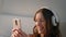 Joyful teenager typing mobile phone in headphones closeup. Carefree girl listen