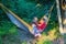 Joyful teenagers - brother and sister ride in a hammock