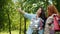 Joyful teenagers taking selfie with shopping bags in city park using smartphone