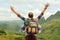 joyful traveller jumping with raised hands enjoying view at mountains