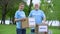 Joyful volunteers holding donation boxes in park smiling on camera, altruism