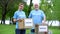 Joyful volunteers holding donation boxes in park smiling on camera, altruism