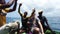 Joyful White tourist with Africans sings a song moving on an old boat in Ocean