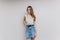 Joyful white woman in denim skirt relaxing during indoor photoshoot. Studio portrait of beautiful european girl isolated