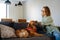 Joyful white woman smiling and playing with her dog at home