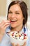 Joyful woman eating cereal in the morning