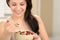 Joyful woman eating healthy cereal