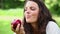 Joyful woman eating a red apple