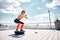 Joyful woman is exercising with fitness equipment on sunny terrace