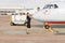 Joyful woman flight attendant standing near aircraft at airport