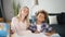 Joyful woman and fun boy is sitting at the table and fooling around with pencil