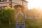 Joyful woman gardener sniffs bunch of green onions on sunny warm spring day. Plant care and harvest concept and hobby