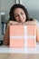 Joyful woman, kitchen scene, hands on present, possible giver