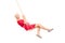 Joyful woman in a red dress swinging on a swing