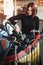 Joyful woman refueling her motorcycle in gas station