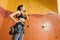 Joyful woman standing behind the climbing wall.