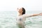 Joyful woman stretching arms in the sea water