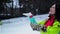 Joyful Woman is Trying to Catch a Snowflakes Enjoying Winter Outdoors. Funny Girl in Bright Colorful Ski Suit and Long