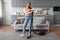 Joyful woman with vacuum in a chic, modern living area