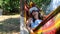 joyful woman wearing virtual reality glasses rests in a hammock near a tree, imagining a dream come true, an invented